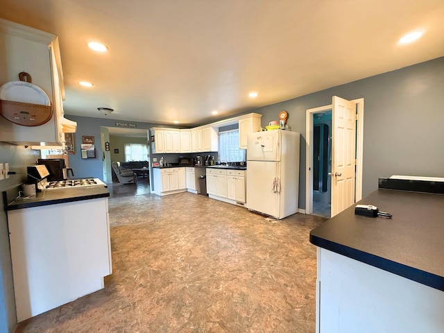512 E Main St, Owosso, MI 48867 - kitchen featuring freestanding refrigerator, dark countertops, recessed lighting, white cabinetry, and light floors