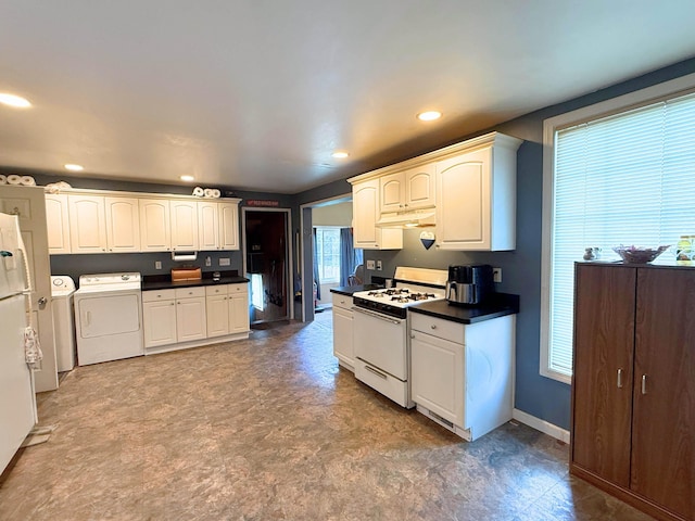 512 E Main St, Owosso, MI 48867 - kitchen with white appliances, washer and clothes dryer, dark countertops, under cabinet range hood, and tile patterned floors