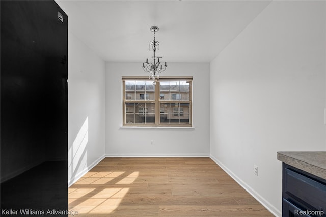 438 Old Pine Way, Walled Lake, MI 48390 - unfurnished dining area featuring light wood finished floors and a chandelier