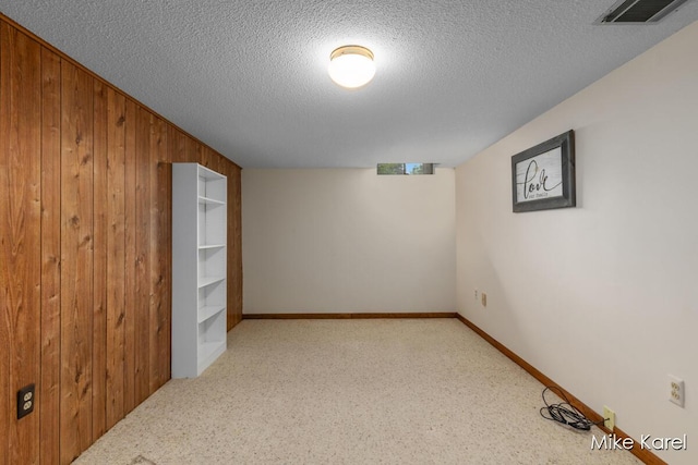 666 Waterview Ct SW, Grandville, MI 49418 - carpeted empty room with wooden walls and a textured ceiling