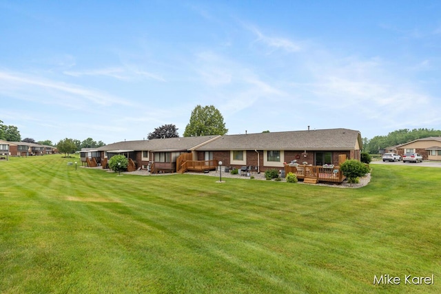 666 Waterview Ct SW, Grandville, MI 49418 - back of house with a wooden deck, a lawn, and brick siding