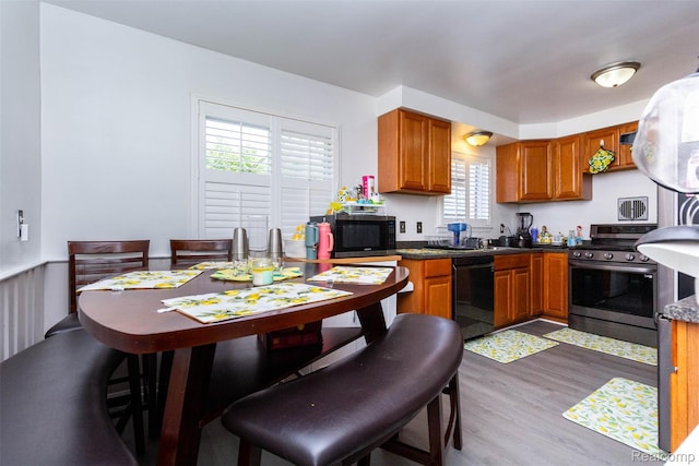 24645 Greenbrier Ave, Eastpointe, MI 48021 - kitchen with appliances with stainless steel finishes, wood finished floors, brown cabinetry, and dark countertops