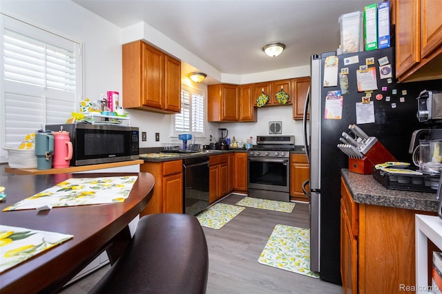 24645 Greenbrier Ave, Eastpointe, MI 48021 - kitchen featuring appliances with stainless steel finishes, brown cabinetry, dark wood-style floors, and dark countertops