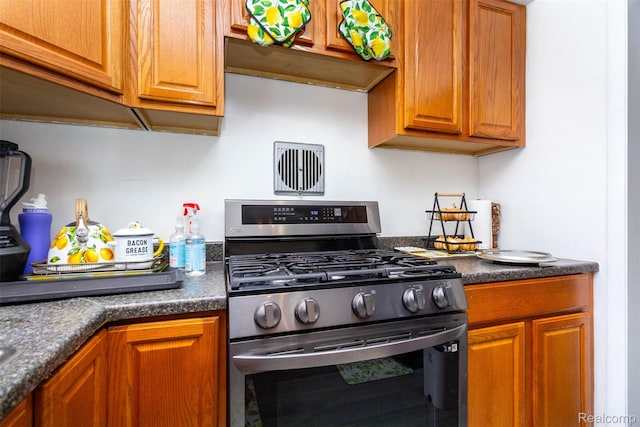 24645 Greenbrier Ave, Eastpointe, MI 48021 - kitchen featuring gas stove, dark countertops, and brown cabinetry