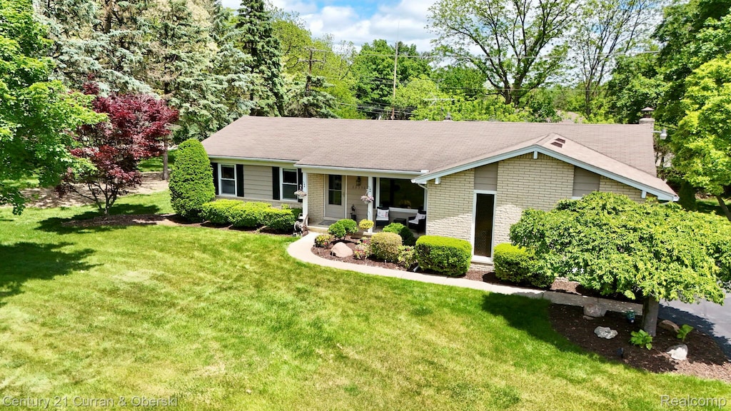 22356 Connemara Dr, Northville, MI 48167 - ranch-style home with a front lawn, brick siding, covered porch, and a chimney
