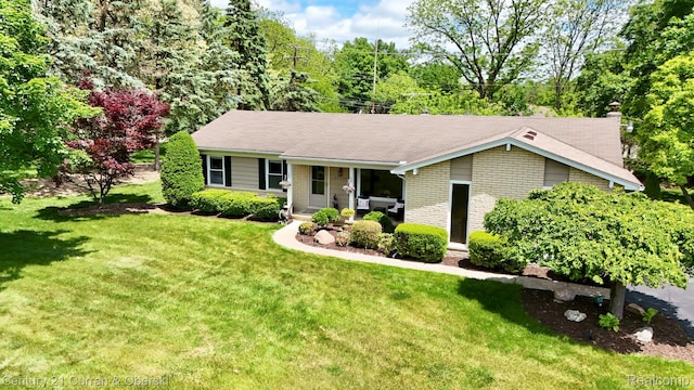 22356 Connemara Dr, Northville, MI 48167 - ranch-style home with a front lawn, brick siding, covered porch, and a chimney
