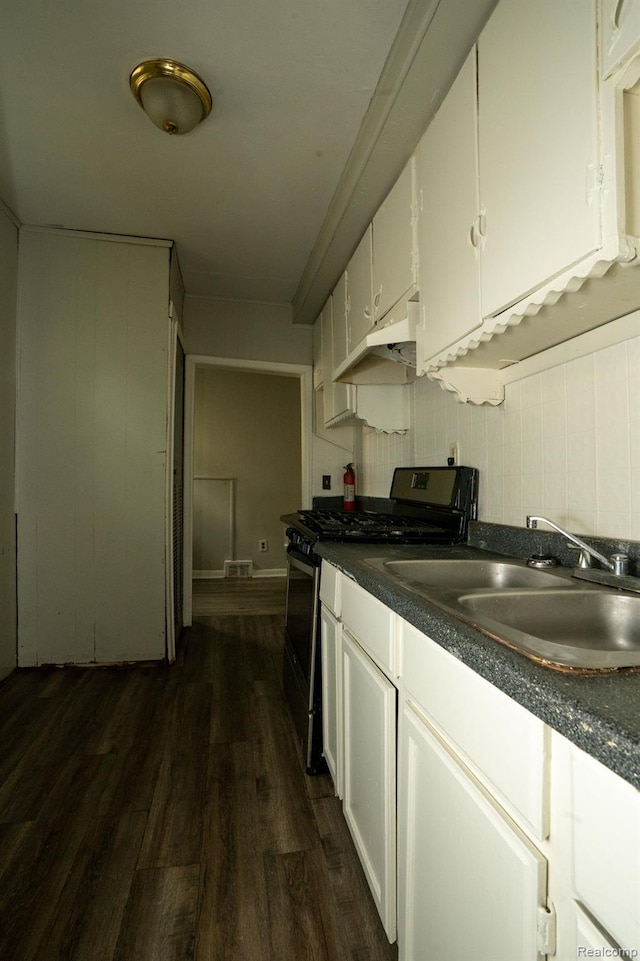 21890 Sharkey St, Clinton Township, MI 48035 - kitchen with range with gas cooktop, under cabinet range hood, white cabinetry, dark wood-type flooring, and dark countertops