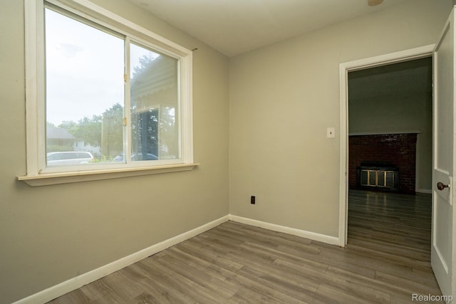 21890 Sharkey St, Clinton Township, MI 48035 - spare room with healthy amount of natural light, wood finished floors, and a brick fireplace