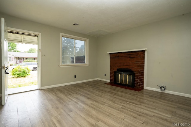 21890 Sharkey St, Clinton Township, MI 48035 - unfurnished living room with wood finished floors and a brick fireplace