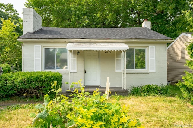 21890 Sharkey St, Clinton Township, MI 48035 - bungalow-style house featuring a chimney, concrete block siding, and a front yard