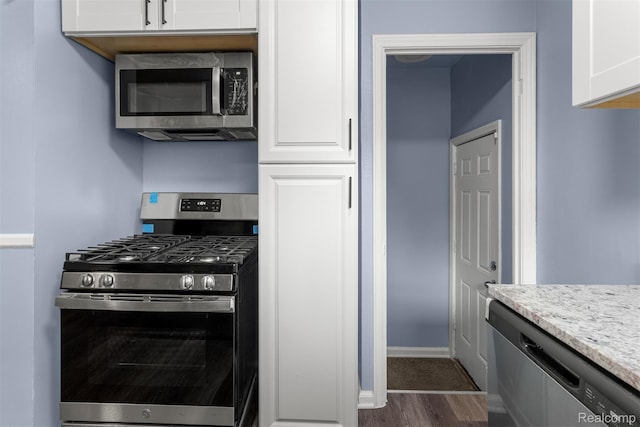 16629 Hubbell St, Garden City, MI 48235 - kitchen with appliances with stainless steel finishes, dark wood-style flooring, white cabinetry, and light stone countertops