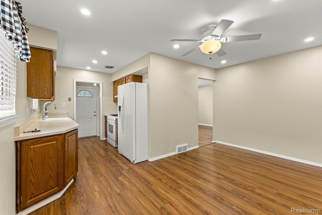 7420 Colonial St, Dearborn Heights, MI 48127 - kitchen featuring white appliances, a ceiling fan, brown cabinetry, wood finished floors, and light countertops