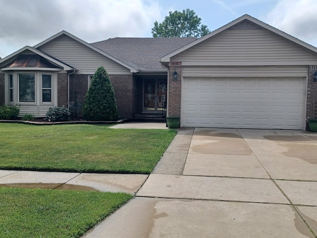 46817 Barbara Dr, Macomb, MI 48044 - ranch-style home featuring brick siding, concrete driveway, a front yard, and a garage