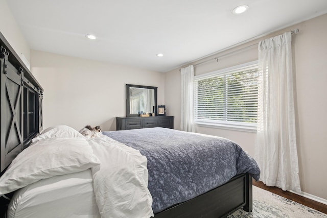 3320 Bluett Dr, Ann Arbor, MI 48105 - bedroom with wood finished floors, a barn door, and recessed lighting