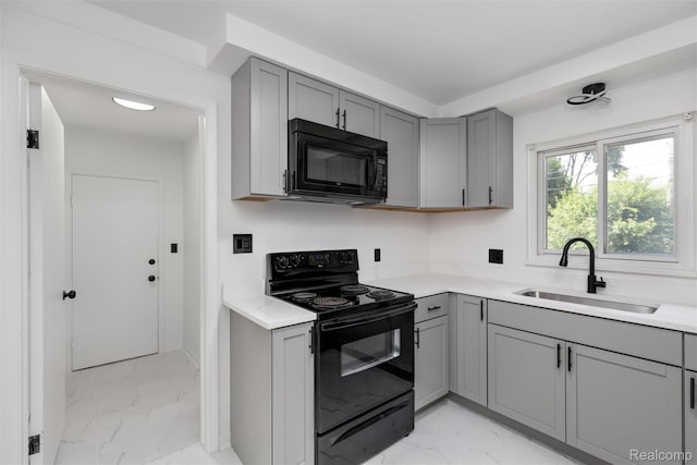 16952 Mount Vernon St, Wixom, MI 48075 - kitchen with black appliances, gray cabinets, light marble finish flooring, and light countertops