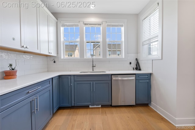 51008 Woodford Dr, Canton, MI 48188 - kitchen featuring stainless steel dishwasher, light wood-style floors, decorative backsplash, white cabinetry, and light countertops