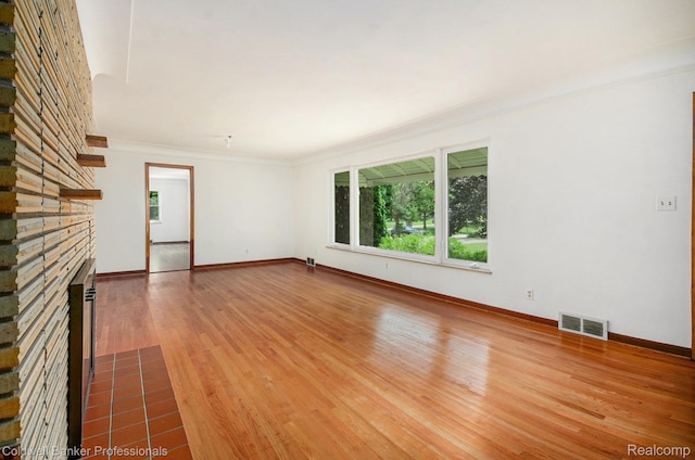 2740 Judah Rd, Lake Orion, MI 48359 - unfurnished living room featuring wood finished floors, a stone fireplace, and ornamental molding