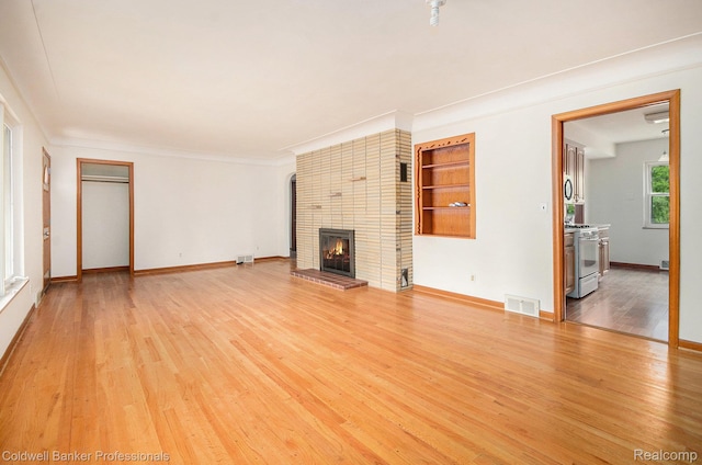 2740 Judah Rd, Lake Orion, MI 48359 - unfurnished living room with a fireplace, light wood-type flooring, and crown molding