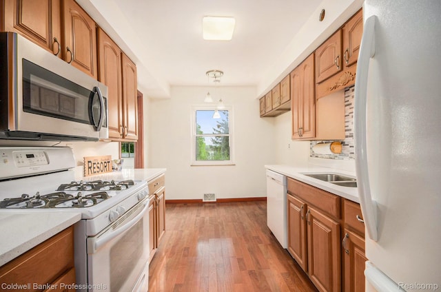 2740 Judah Rd, Lake Orion, MI 48359 - kitchen with white appliances, light countertops, light wood finished floors, and brown cabinetry
