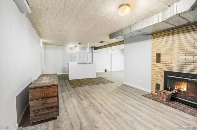 2740 Judah Rd, Lake Orion, MI 48359 - finished basement featuring wood finished floors, a brick fireplace, and fridge