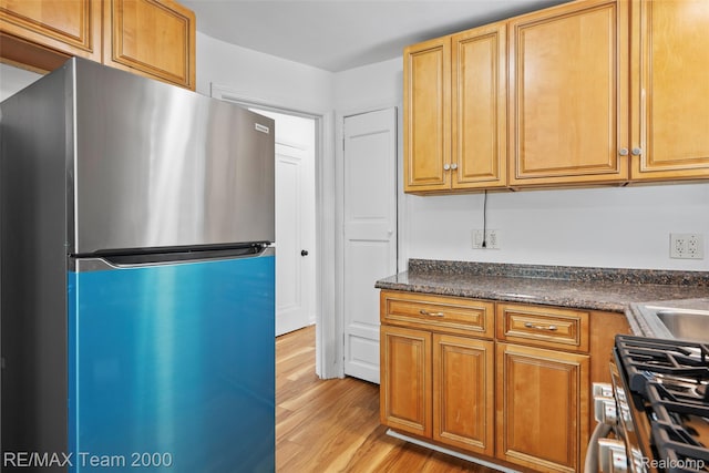 26389 Annapolis St, Dearborn Heights, MI 48125 - kitchen featuring freestanding refrigerator, stove, light wood finished floors, and dark countertops