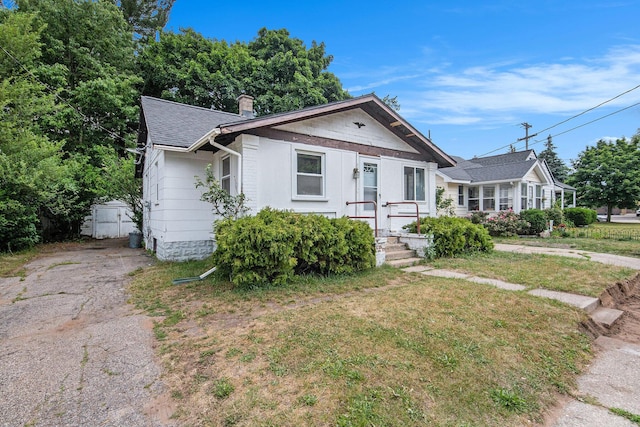 1137 Merrifield St SE, Grand Rapids, MI 49507 - view of front of property featuring roof with shingles, a front lawn, and a chimney