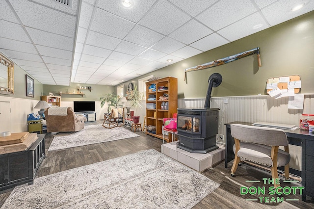 11829 Hoskins Ave NE, Cedar Springs, MI 49319 - living room with a wood stove, wood finished floors, a wainscoted wall, and a drop ceiling