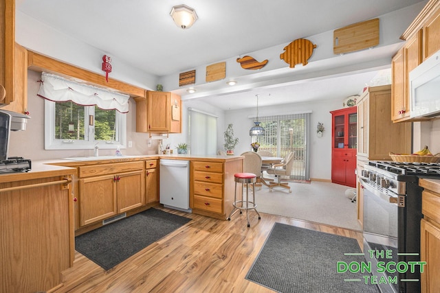 11829 Hoskins Ave NE, Cedar Springs, MI 49319 - kitchen with white appliances, a peninsula, light countertops, light wood-type flooring, and hanging light fixtures