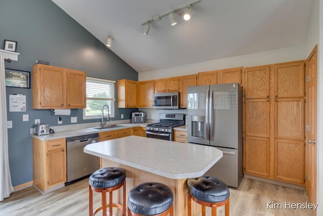 4233 Ives Farm Ln NE, Cedar Springs, MI 49319 - kitchen featuring appliances with stainless steel finishes, a kitchen breakfast bar, light countertops, light wood-style flooring, and track lighting