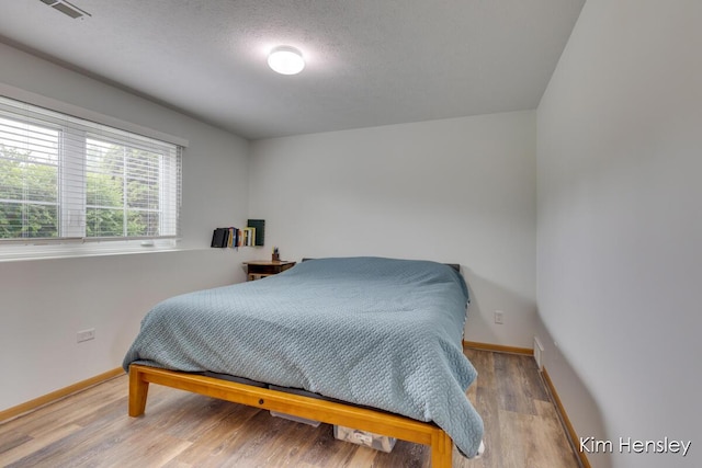 4233 Ives Farm Ln NE, Cedar Springs, MI 49319 - bedroom with wood finished floors and a textured ceiling