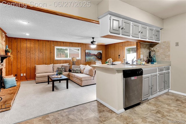8798 Lozen Dr, Sterling Heights, MI 48313 - kitchen with stainless steel dishwasher, healthy amount of natural light, wood walls, light countertops, and a peninsula