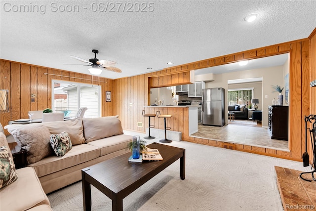 8798 Lozen Dr, Sterling Heights, MI 48313 - living area with a textured ceiling, wooden walls, ceiling fan, and light carpet