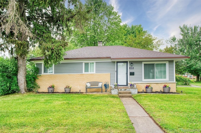 1478 Desoto Ave, Ypsilanti, MI 48198 - view of front of property with brick siding, a front yard, a chimney, and roof with shingles