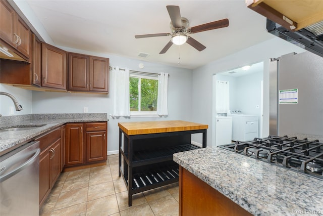 1478 Desoto Ave, Ypsilanti, MI 48198 - kitchen featuring stainless steel dishwasher, washer and clothes dryer, a ceiling fan, light stone countertops, and cooktop
