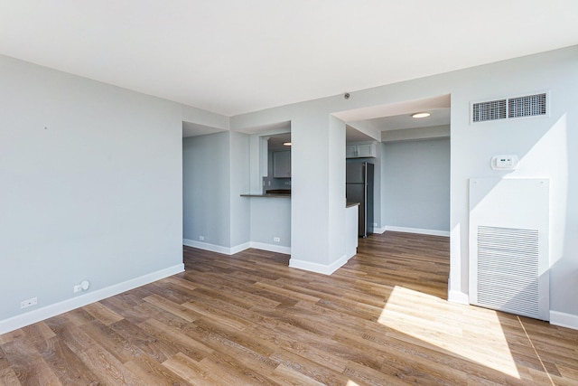 3320 Spinnaker Ln Unit 16D, Detroit, MI 48207 - unfurnished living room with wood finished floors and a heating unit