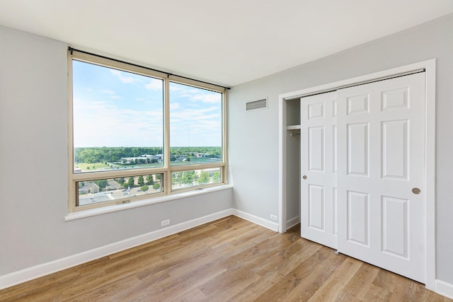 3320 Spinnaker Ln Unit 16D, Detroit, MI 48207 - unfurnished bedroom featuring light wood finished floors and a closet