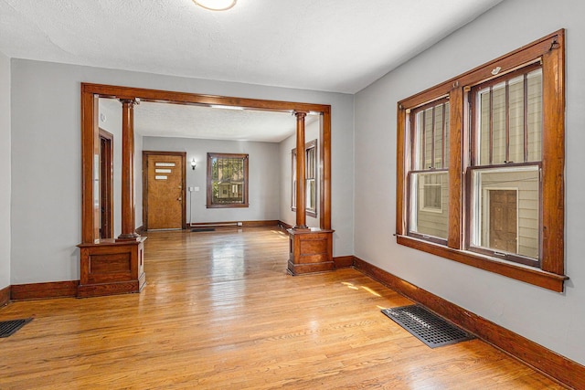 941 Mcreynolds Ave NW, Grand Rapids, MI 49504 - unfurnished room with ornate columns and light wood finished floors