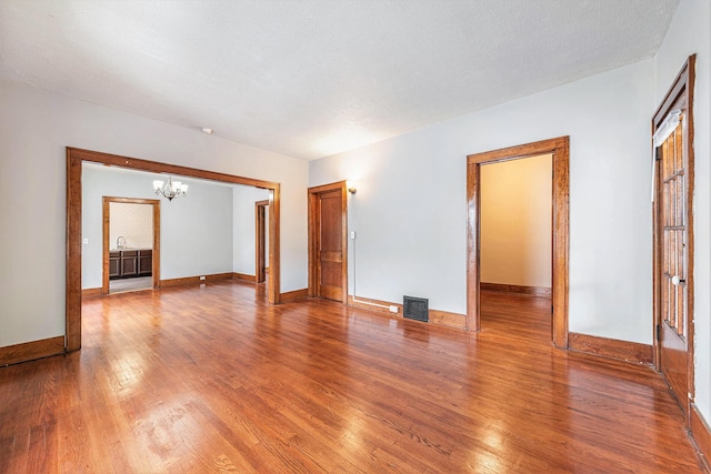 941 Mcreynolds Ave NW, Grand Rapids, MI 49504 - unfurnished room featuring a chandelier and wood finished floors