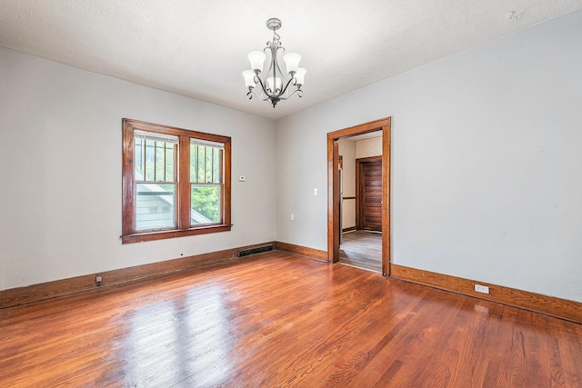 941 Mcreynolds Ave NW, Grand Rapids, MI 49504 - unfurnished room with a chandelier and wood finished floors