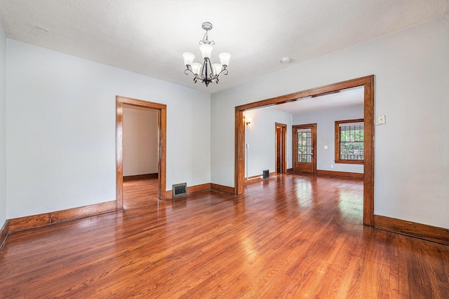 941 Mcreynolds Ave NW, Grand Rapids, MI 49504 - empty room featuring wood finished floors, a chandelier, and a smoke detector
