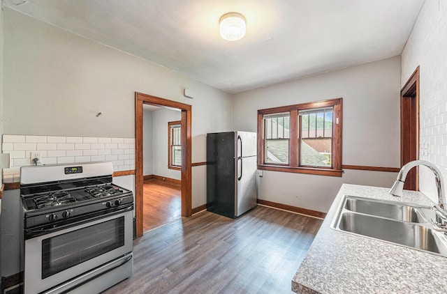 941 Mcreynolds Ave NW, Grand Rapids, MI 49504 - kitchen with appliances with stainless steel finishes, plenty of natural light, wood finished floors, and tasteful backsplash