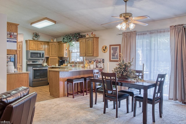 845 Riverlane Dr, Owosso, MI 48867 - dining area with lofted ceiling, light colored carpet, and ceiling fan