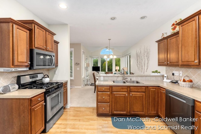 1809 Woodside Trl NW, Grand Rapids, MI 49504 - kitchen with stainless steel appliances, a peninsula, brown cabinets, light wood-style floors, and open floor plan