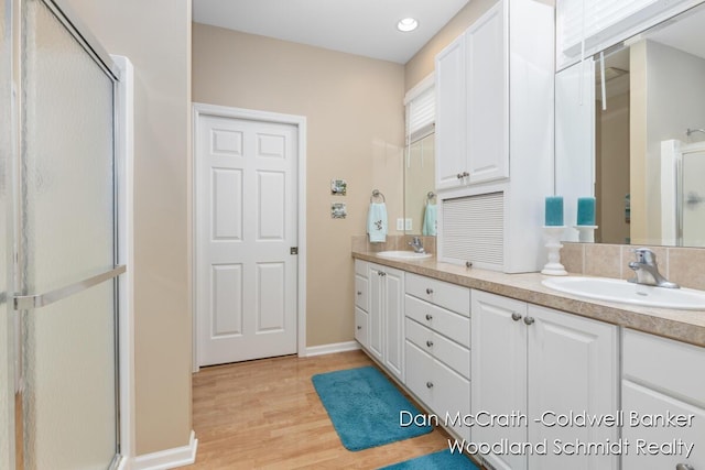 1809 Woodside Trl NW, Grand Rapids, MI 49504 - full bathroom with double vanity, a stall shower, wood finished floors, and recessed lighting