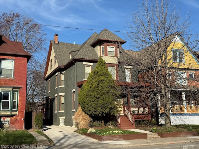 4751 Trumbull St, Detroit, MI 48208 - victorian-style house featuring a shingled roof, a chimney, and brick siding