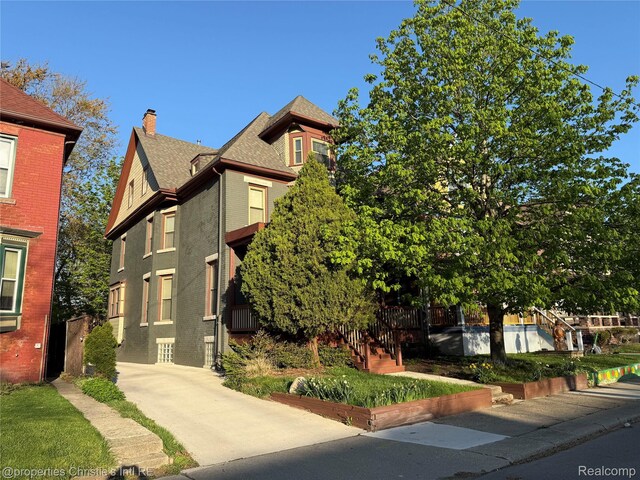 4751 Trumbull St, Detroit, MI 48208 - view of front of property featuring a chimney, brick siding, and a shingled roof