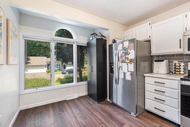 3342 Woodwind Dr NE, Grand Rapids, MI 49525 - kitchen featuring appliances with stainless steel finishes, dark wood-type flooring, white cabinets, decorative backsplash, and light countertops