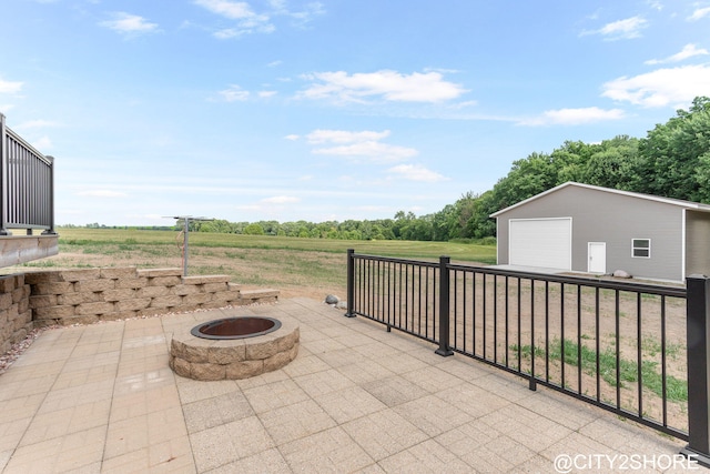 3905 Sunset Vw, Wayland, MI 49348 - view of patio featuring a fire pit, a detached garage, an outbuilding, and a view of countryside
