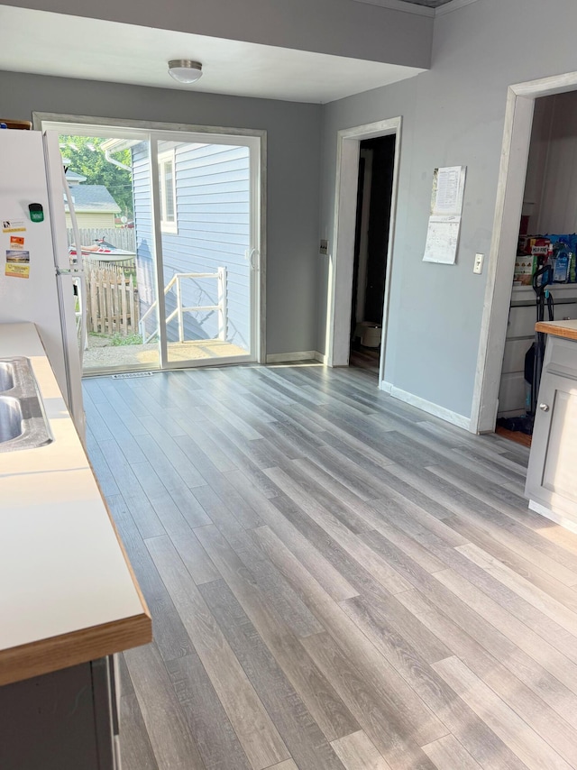 423 E Prairie St, Vicksburg, MI 49097 - unfurnished living room featuring light wood-style flooring and baseboards