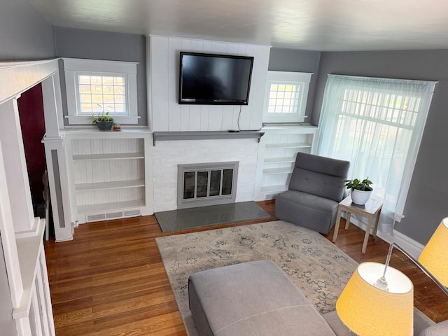 423 E Prairie St, Vicksburg, MI 49097 - living room featuring wood finished floors, a brick fireplace, and built in features